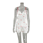 Bella Mia spring homewear set featuring satin suspender shorts and heart-print two-piece pajamas for women.