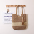Woven two-tone tassel shoulder bag by Wanita Store, casual straw beach bag with tassel accents for women.