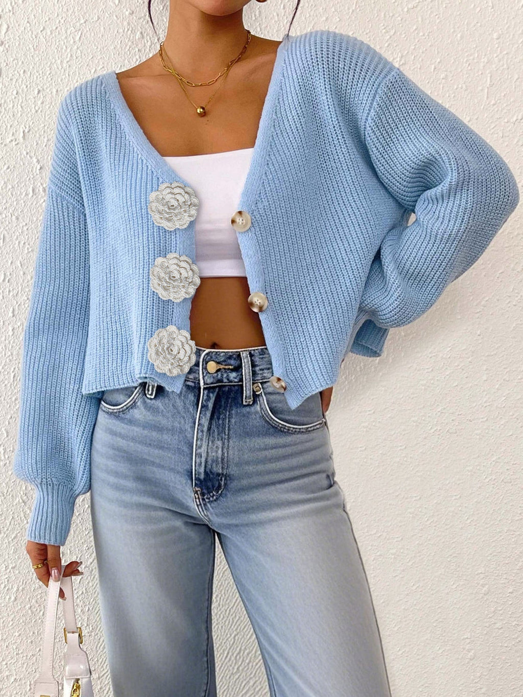 Women’s knitted sweater by Bella Mia featuring floral buttons, short cardigan style, perfect for casual streetwear.