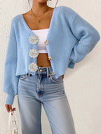 Women’s knitted sweater by Bella Mia featuring floral buttons, short cardigan style, perfect for casual streetwear.