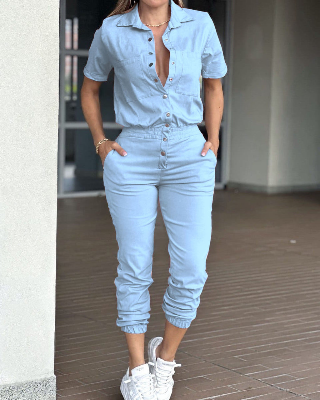 Casual women's ankle-tied jumpsuit by Wanita Store with collar, pockets, elastic waist, and button details.