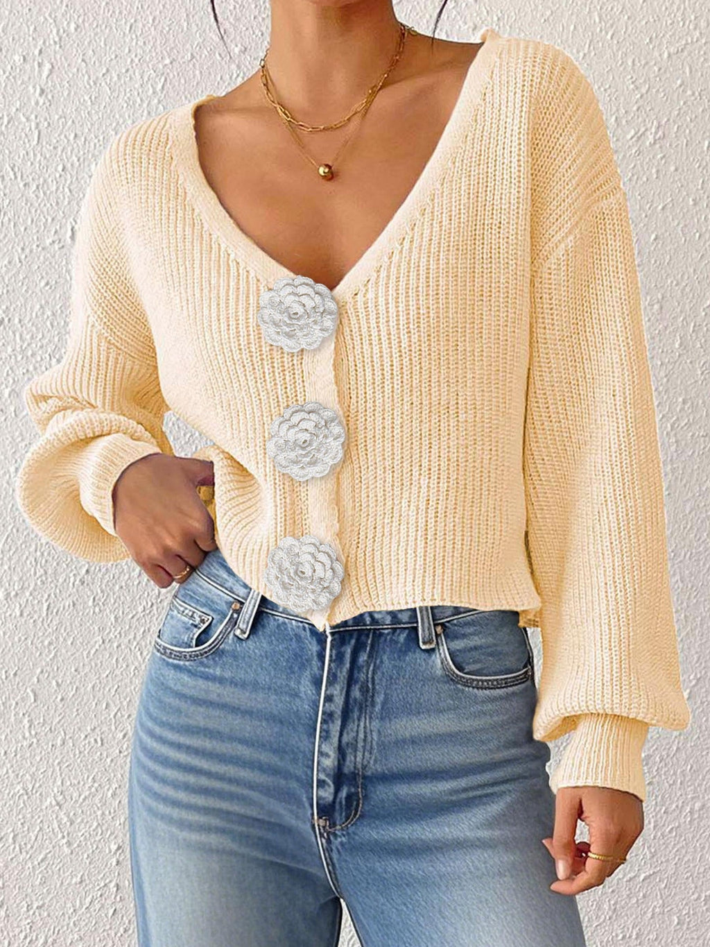Women’s knitted sweater cardigan by Bella Mia with floral buttons, short hipster style, and hand-hook details.