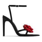 Black satin high heel sandals for women with 11cm stiletto heels, pointed toes, rhinestone floral accents, by Bella Mia