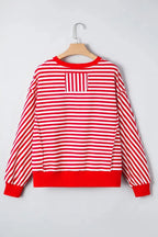 Red striped drop shoulder long sleeve top with exposed seams from Gilded Glamour Shop, featuring relaxed fit and stylish design.