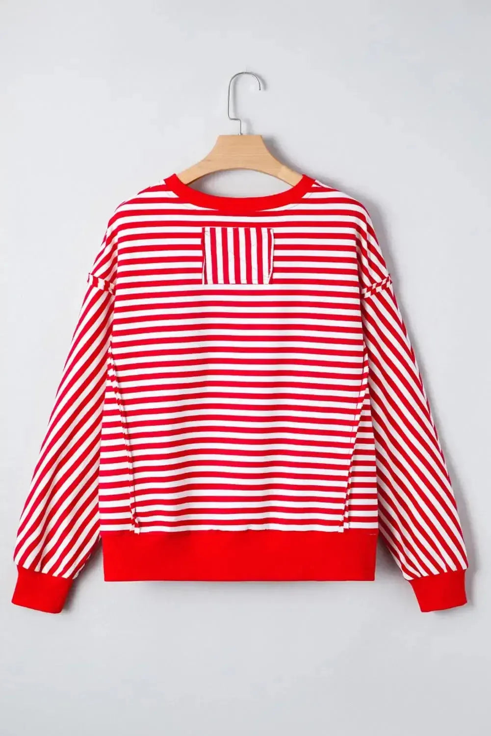 Red striped drop shoulder long sleeve top with exposed seams from Gilded Glamour Shop, featuring relaxed fit and stylish design.