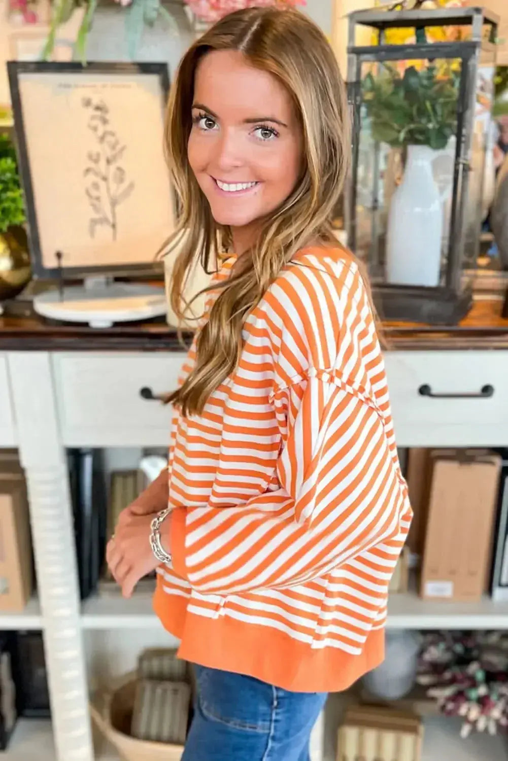 Red striped drop shoulder long sleeve top with exposed seams by Gilded Glamour Shop, showcasing casual style and relaxed fit.