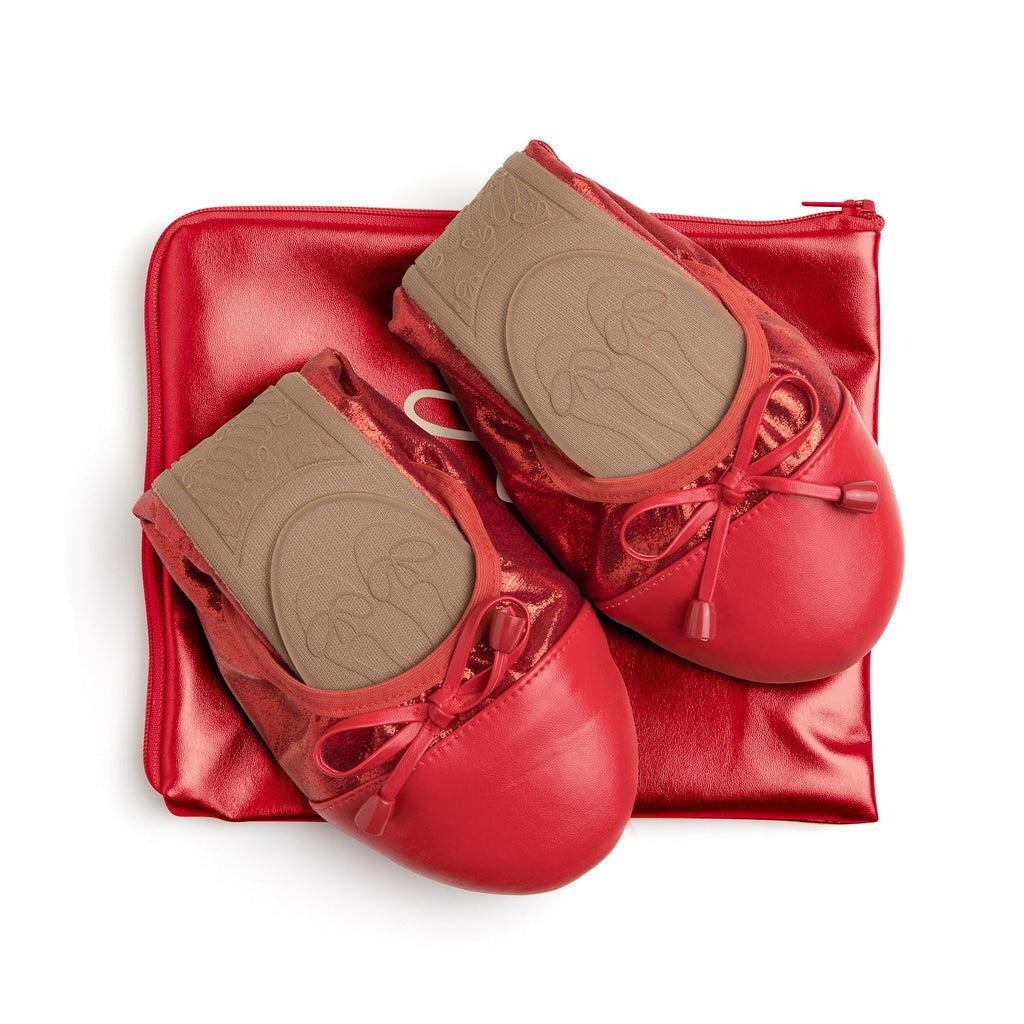 Talaria Flats premium ruby red flats shoes resting on a bag, showcasing their stylish design and vibrant color.