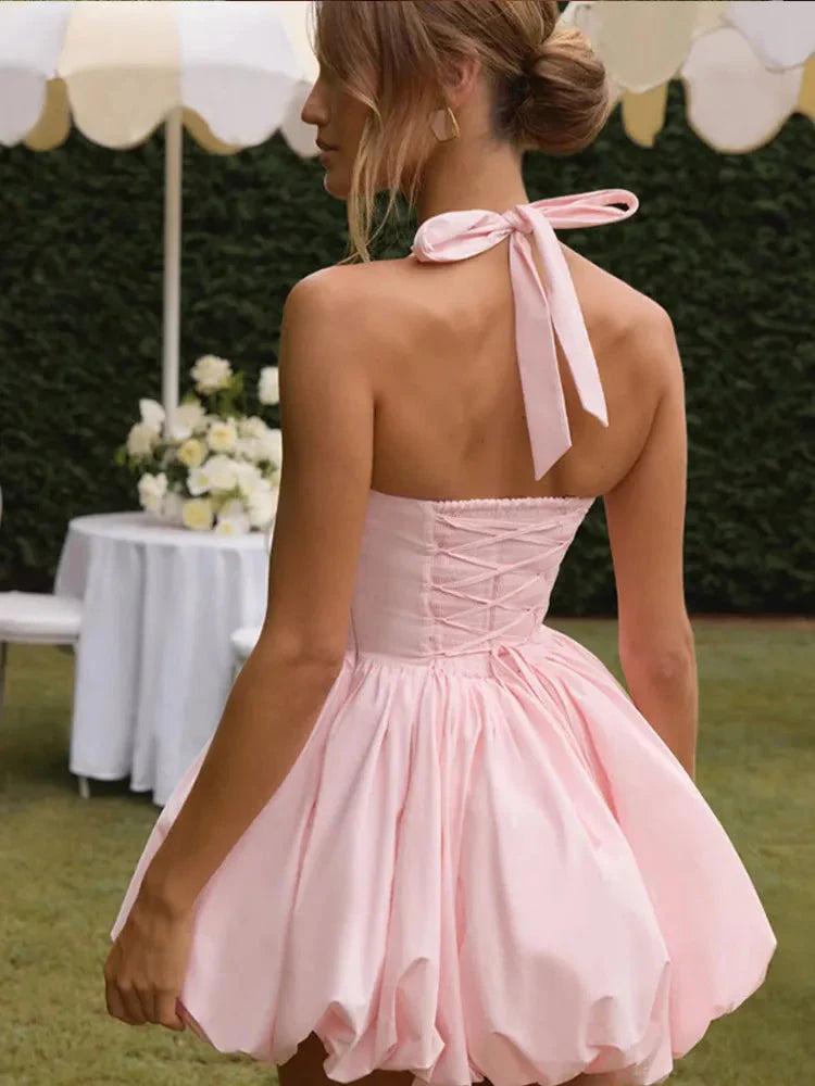Women’s pink corset puffball-hem mini dress by FitiqueFit, showing a fitted bodice, puff sleeves, and a short flared hem.
