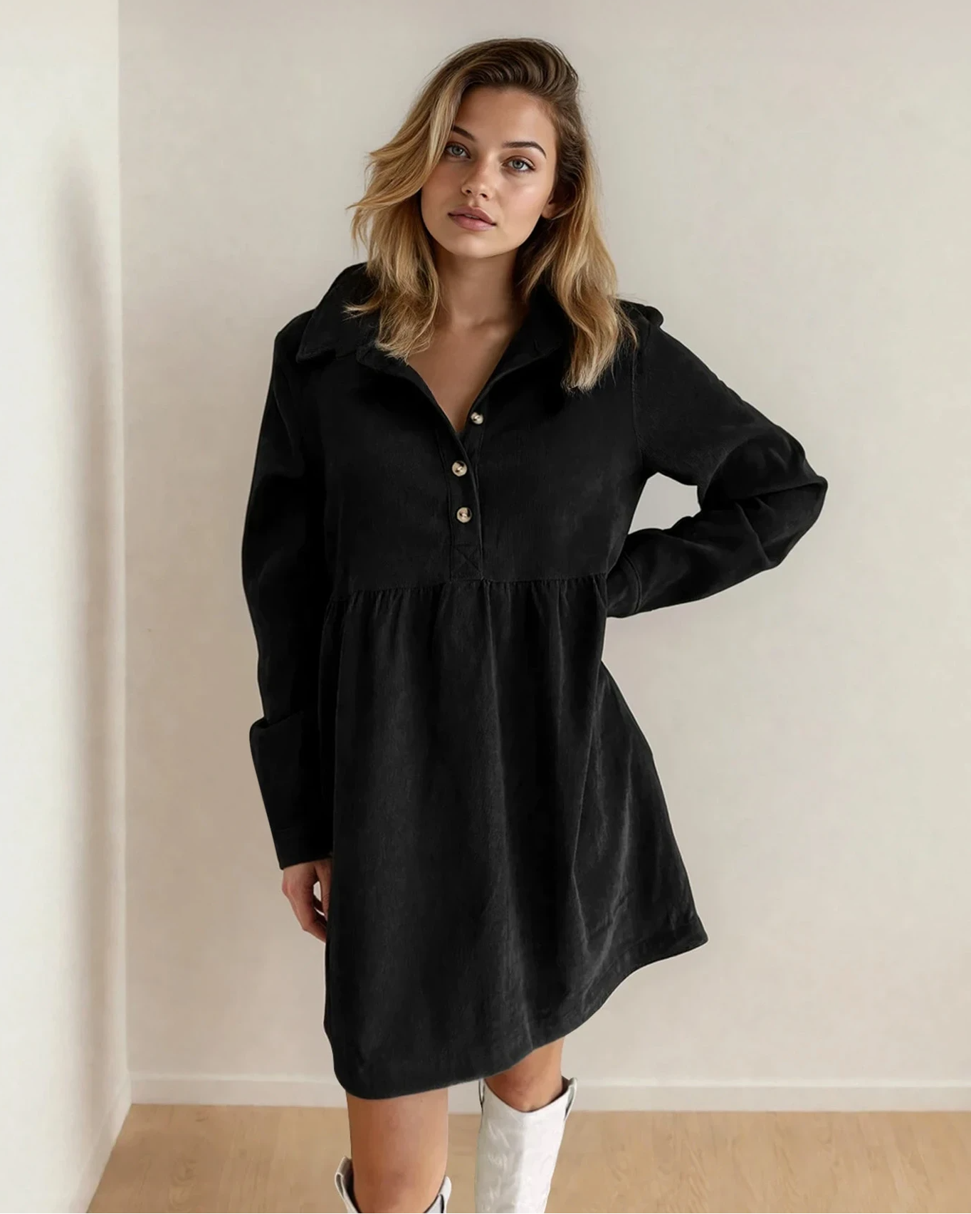 Black Abigail corduroy long sleeve dress with half button collar from Indie & Co., shown on a hardwood floor background.
