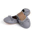 Talaria Flats in stone grey, half-folded, showcasing their sleek, comfortable shoe design with a smooth, matte finish.