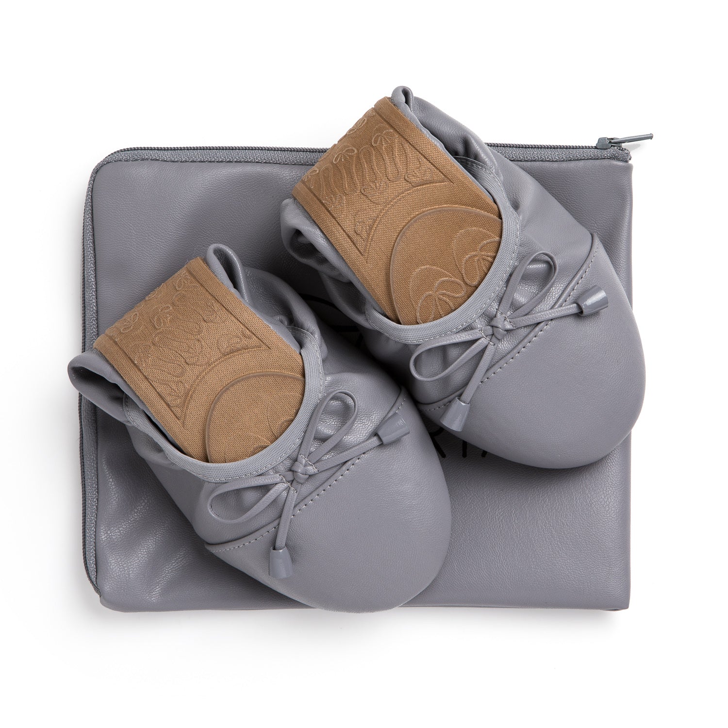 Talaria Flats in stone grey, stylish shoes placed on top of a bag, showcasing their sleek design and comfortable fit.