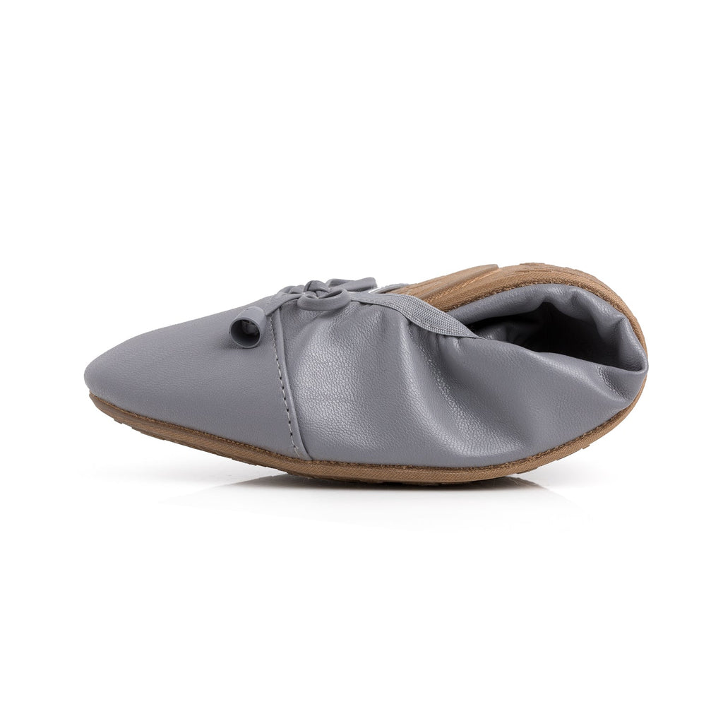 Pair of Talaria Flats in stone grey, single folded to show the soft leather exterior and comfortable slip-on design.