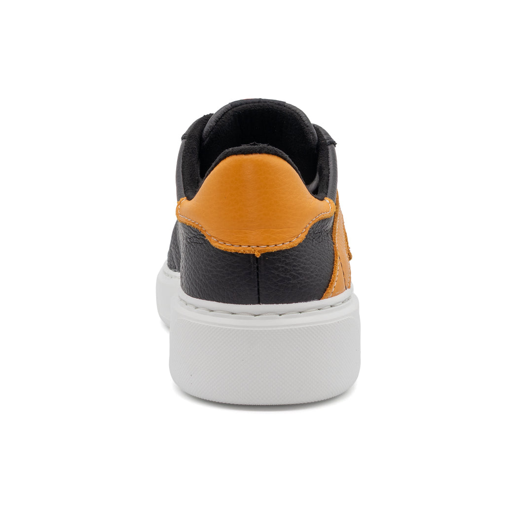 Black and gold two-tone lowtop sneaker by BLKSWN Footwear, showing the back view of the stylish design.