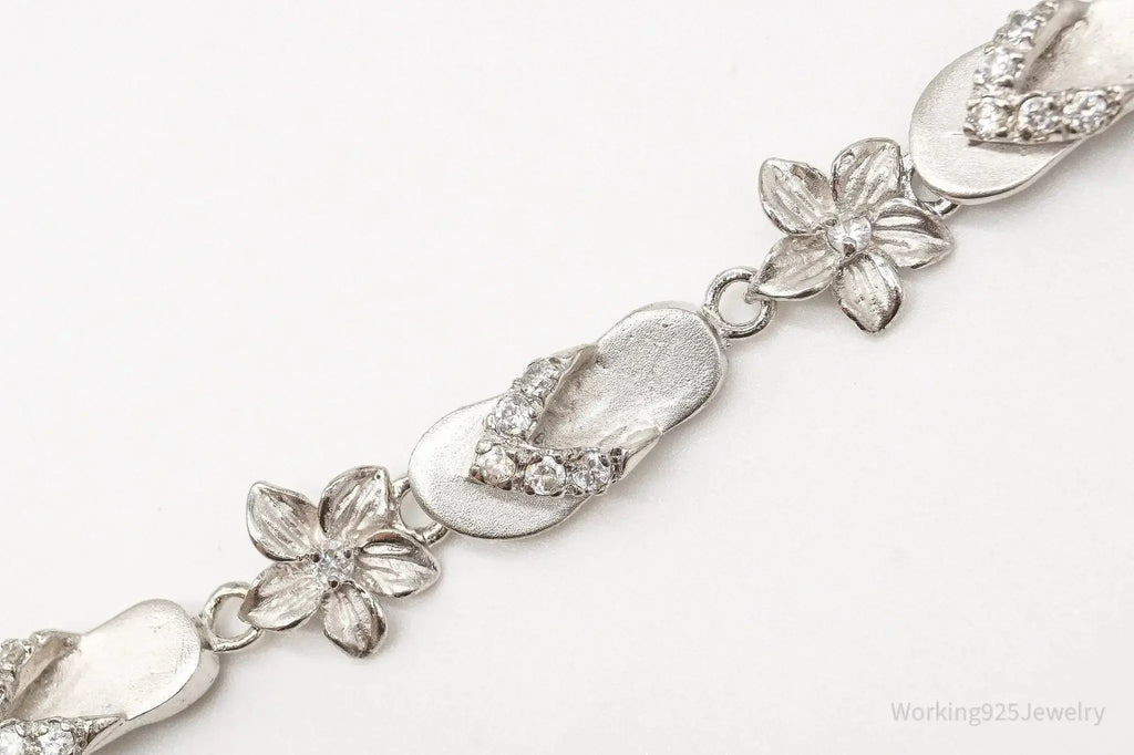 Vintage cubic zirconia sandals and flowers sterling silver bracelet, elegant jewelry pieces with intricate design details.