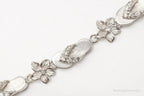 Vintage cubic zirconia sandals and flowers sterling silver bracelet, elegant jewelry pieces with intricate design details.