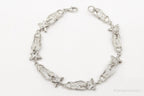 Vintage sterling silver bracelet with floral design and cubic zirconia sandals charm, crafted by Plush Fashion Hub.