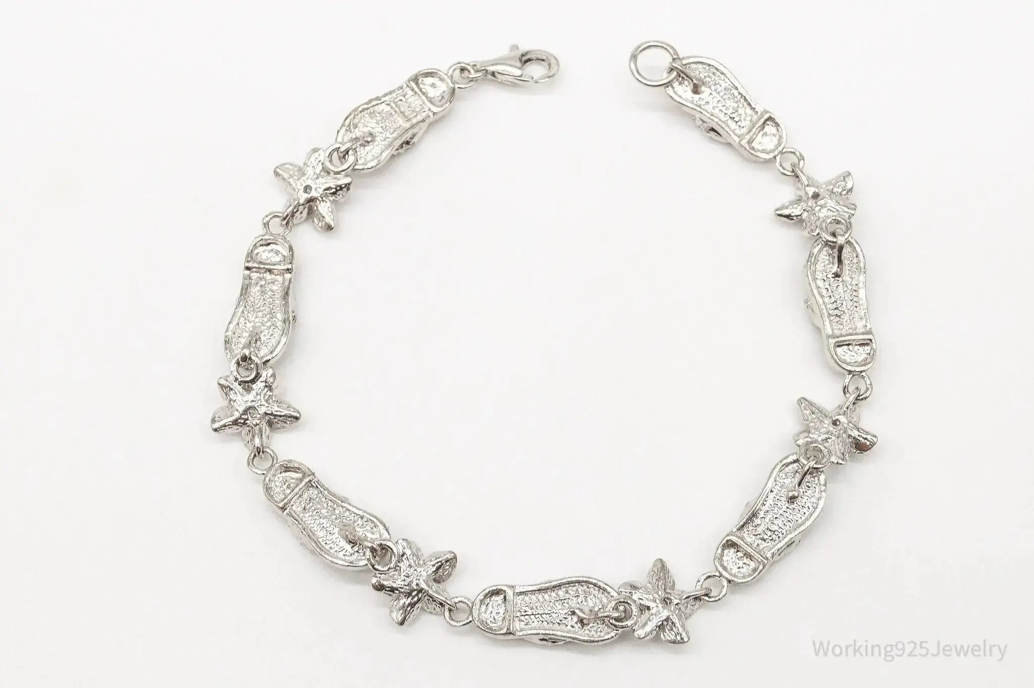 Vintage sterling silver bracelet with floral design and cubic zirconia sandals charm, crafted by Plush Fashion Hub.