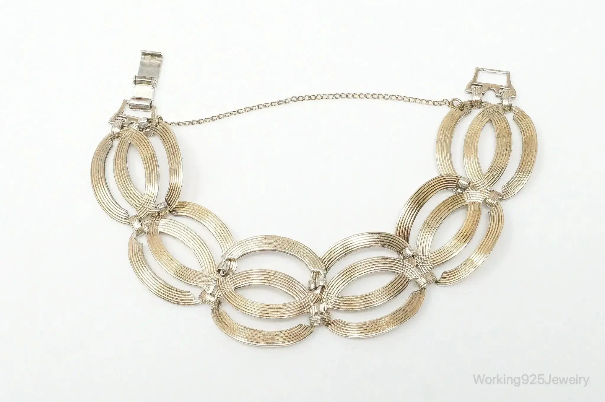 Vintage designer sterling silver bracelet with 14K gold accents, featuring art deco symmetrical design.