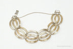 Vintage designer silver bracelet with 14K gold accents, Art Deco style, featuring symmetrical geometric patterns.