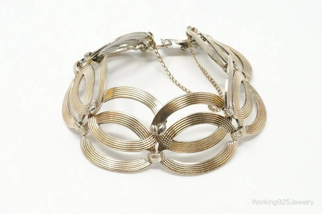 Vintage designer silver bracelet with 14K gold accents in Art Deco style, featuring intricate symmetrical patterns.