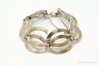 Vintage designer silver bracelet with 14K gold accents in Art Deco style, featuring intricate symmetrical patterns.