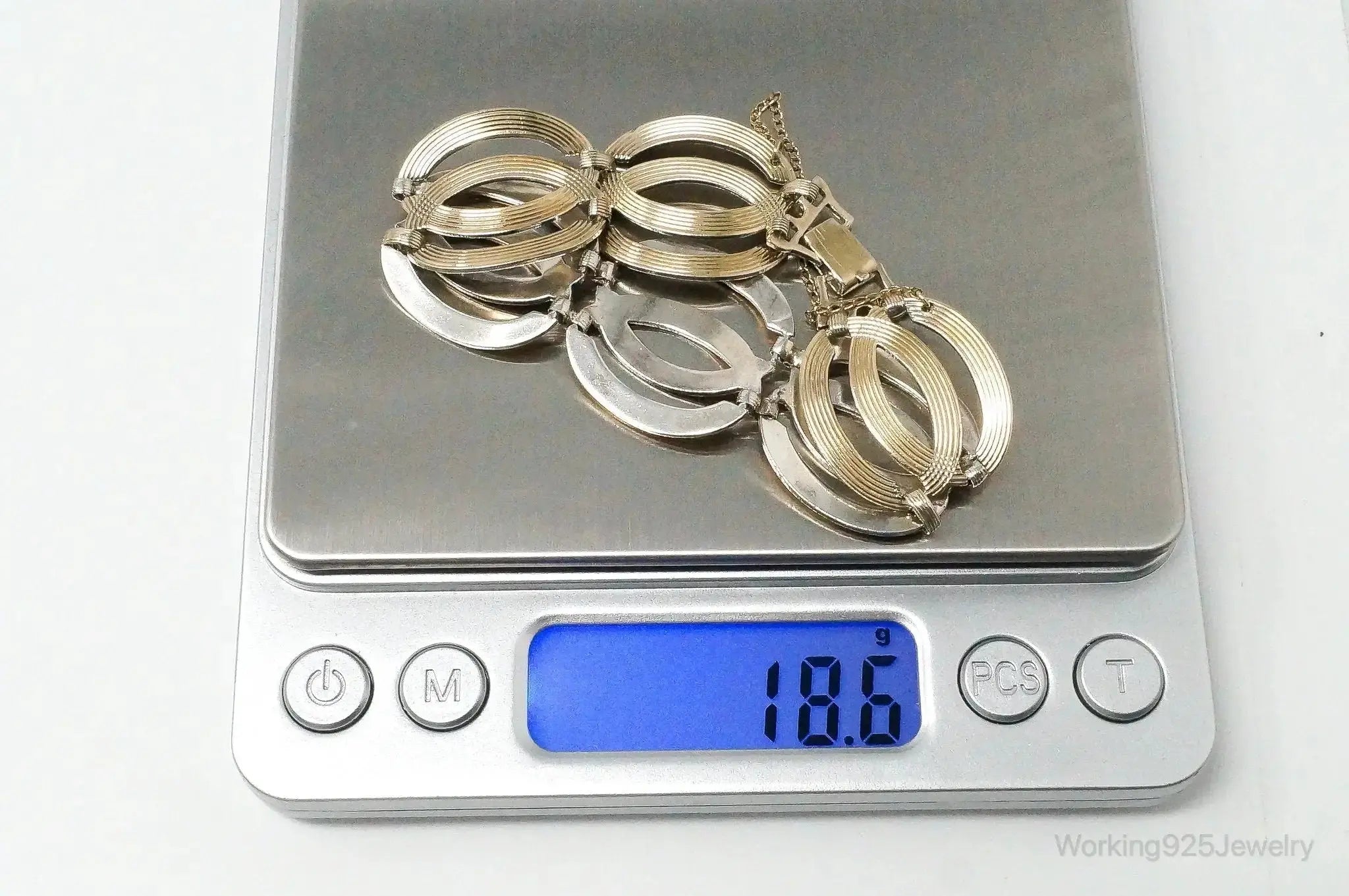 Vintage designer silver bracelet with gold accents, art deco style, featuring intricate geometric patterns, crafted in sterling silver.
