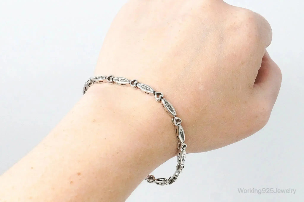 Sterling silver bracelet with vintage diamond-linked hearts design, featuring intricate heart-shaped links for a classic jewelry look.