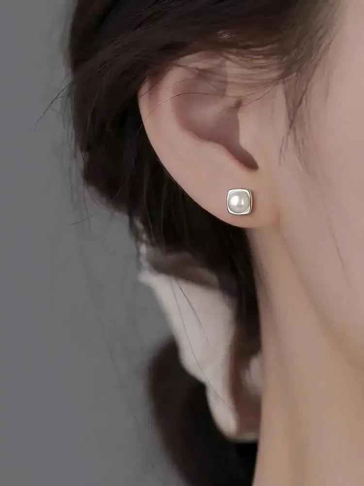 Sterling silver pearl stud earrings featuring minimalist geometric design, elegant jewelry by Plush Fashion Hub.