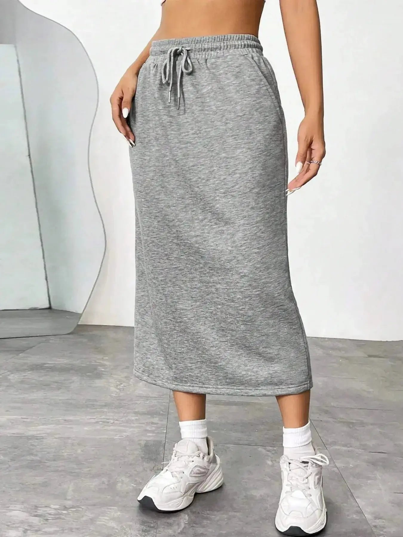 Women's casual drawstring midi skirt with pockets and side slit, trendy skirt from Trendsi, shown in a relaxed, stylish fit.