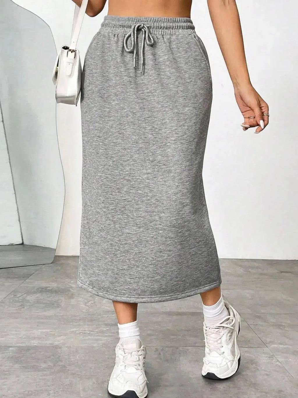 Women's casual drawstring midi skirt with side slit and pockets, made by Trendsi, shown in a relaxed, stylish design.