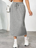 Women's casual drawstring midi skirt with side slit and pockets, made by Trendsi, shown in a relaxed, stylish design.