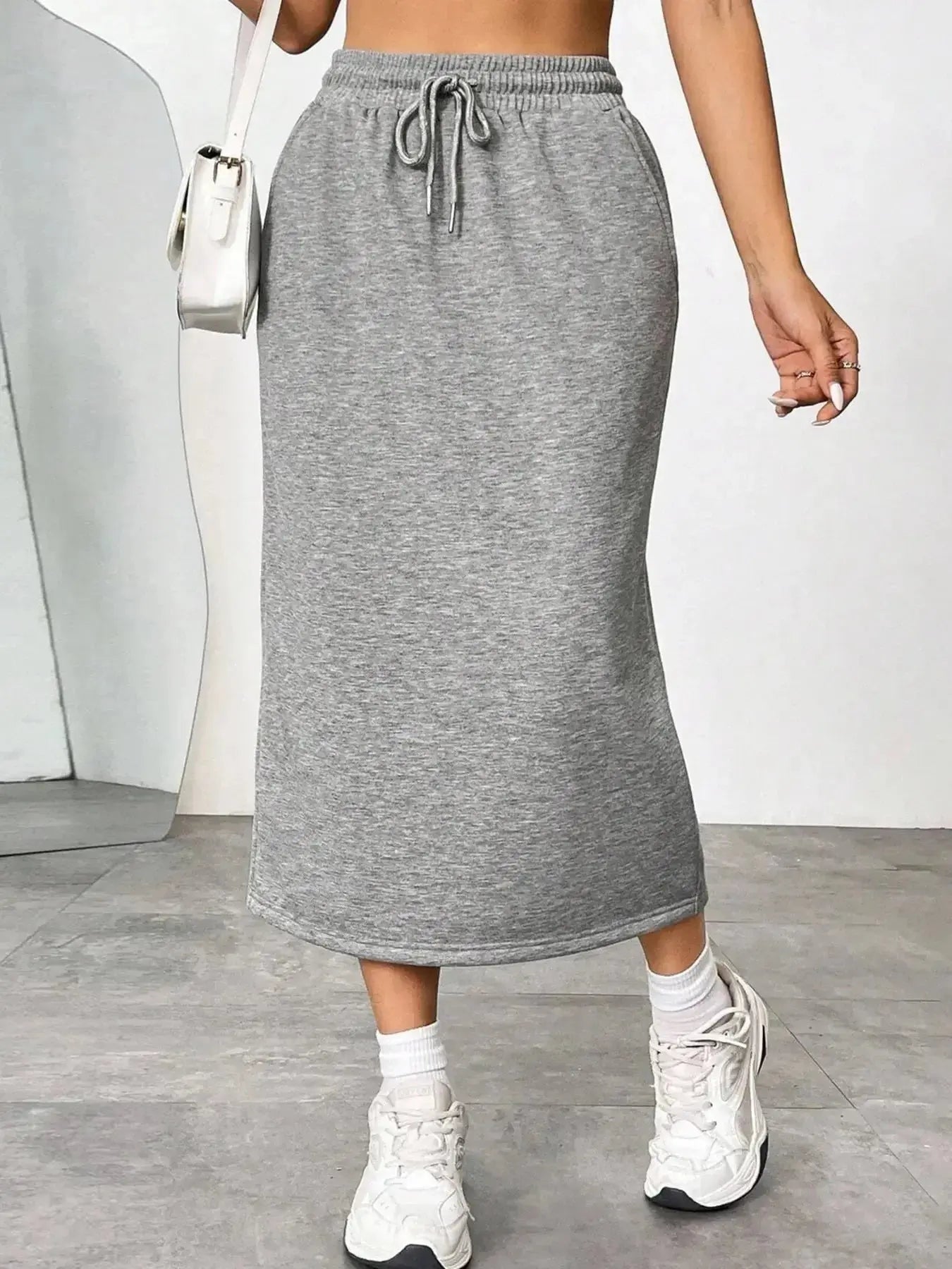 Women's casual drawstring midi skirt with side slit and pockets, made by Trendsi, shown in a relaxed, stylish design.