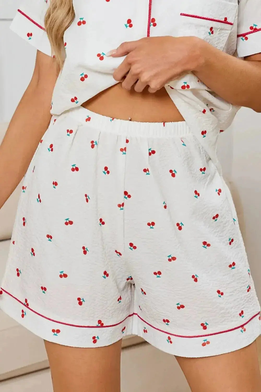 Women's cheery print pajama set with collared button-down top and matching shorts by Trendsi, perfect for comfortable lounging.