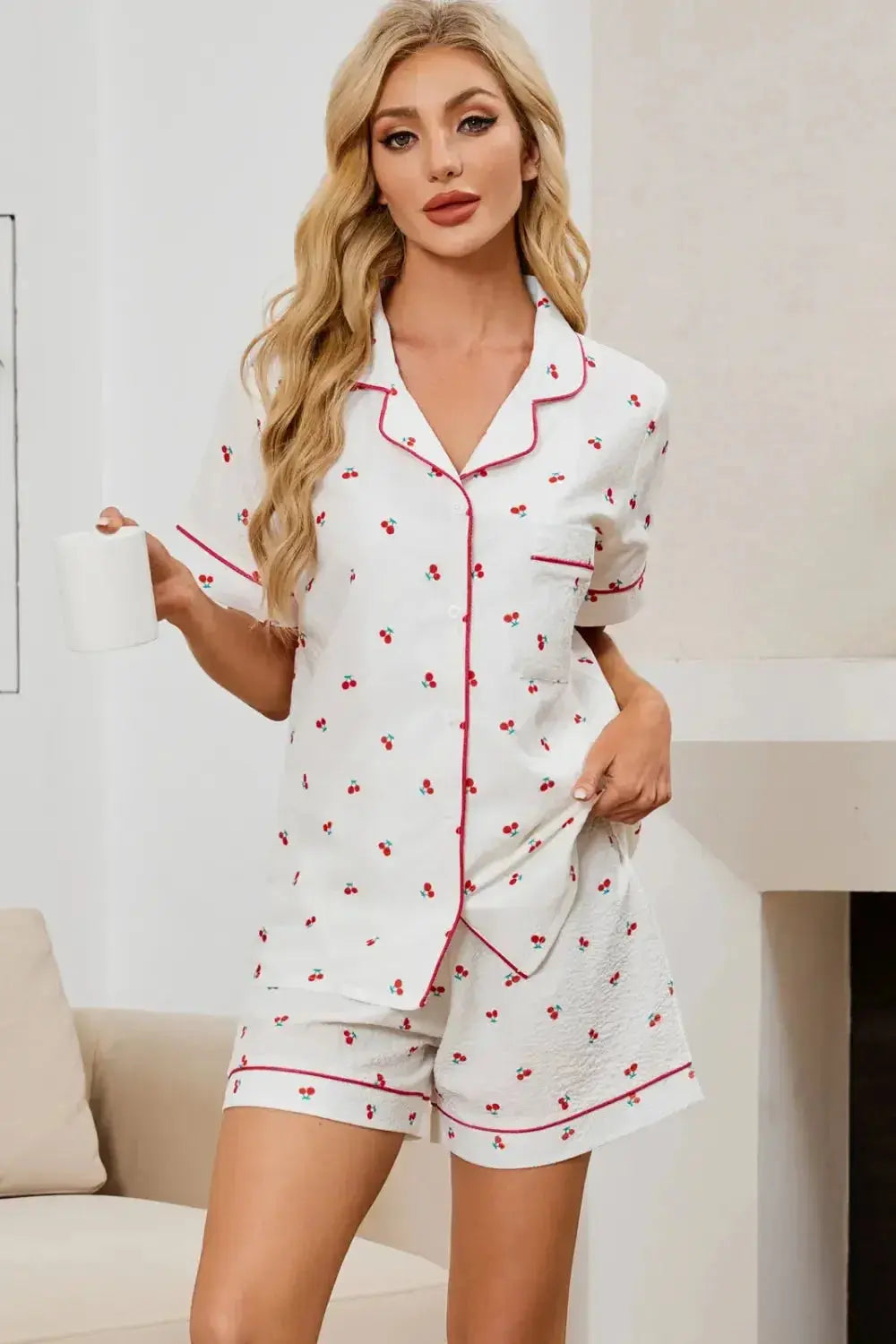 Women’s cheery print pajama top and shorts lounge set by Trendsi, featuring a collared button-down pajama top and matching shorts.