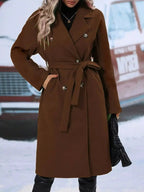 Women's double-breasted trench coat with tie waist belt, stylish outerwear from Trendsi, shown hanging with classic collar and belted waist.