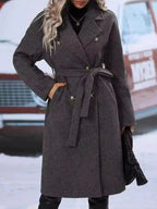 Women's double-breasted trench coat with tie waist belt, stylish and classic outerwear by Trendsi, shown on a model.