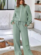 Women's drop shoulder zip-up jacket and jogger lounge set, comfortable two-piece sweat suit by Trendsi in soft fabric.