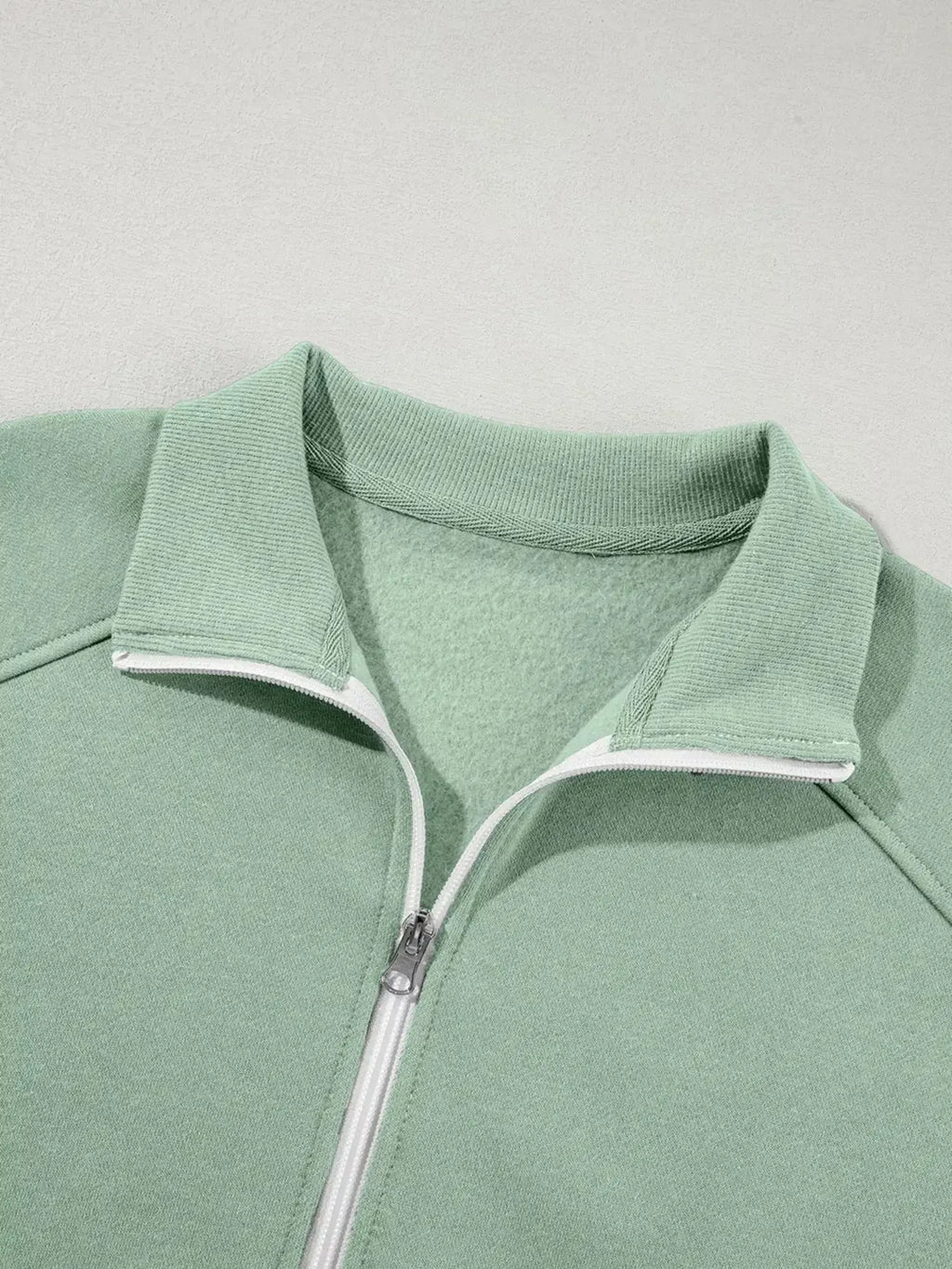 Women's drop shoulder zip-up jacket and jogger sweat suit two-piece lounge set by Trendsi, featuring a relaxed fit and comfortable fabric.