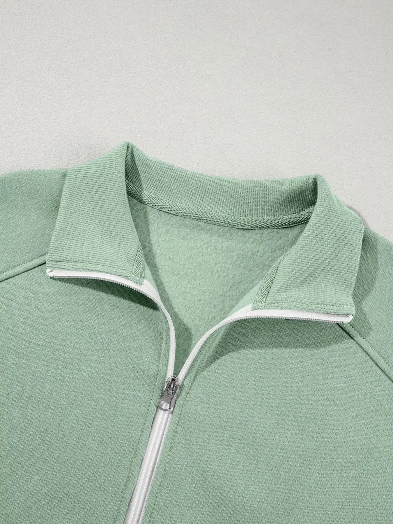 Women's drop shoulder zip-up jacket and jogger sweat suit two-piece lounge set by Trendsi, featuring a relaxed fit and comfortable fabric.