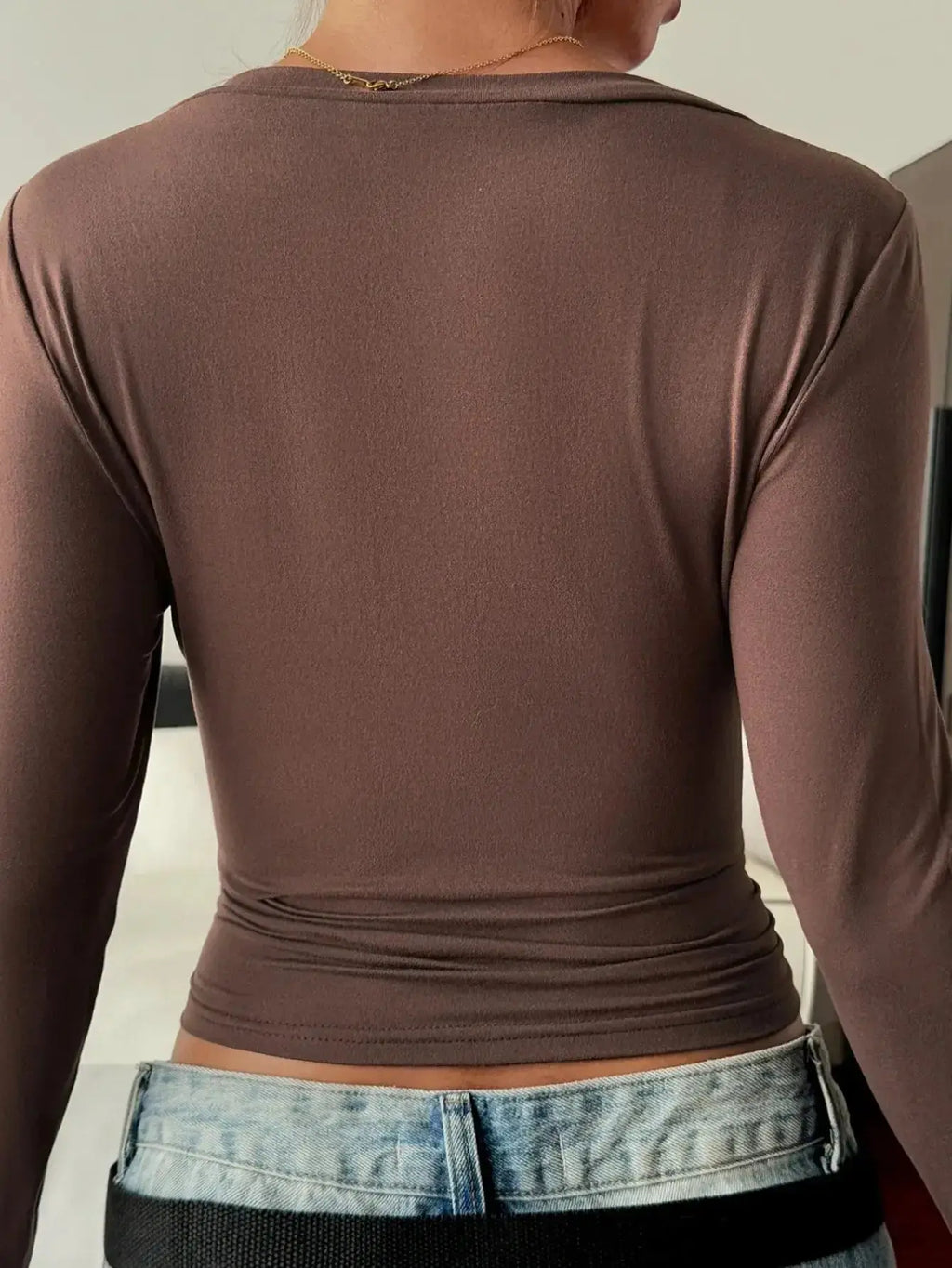 Women’s fitted V-neck long sleeve T-shirt by Trendsi, showcasing a casual, comfortable essential in soft fabric with a flattering fit.