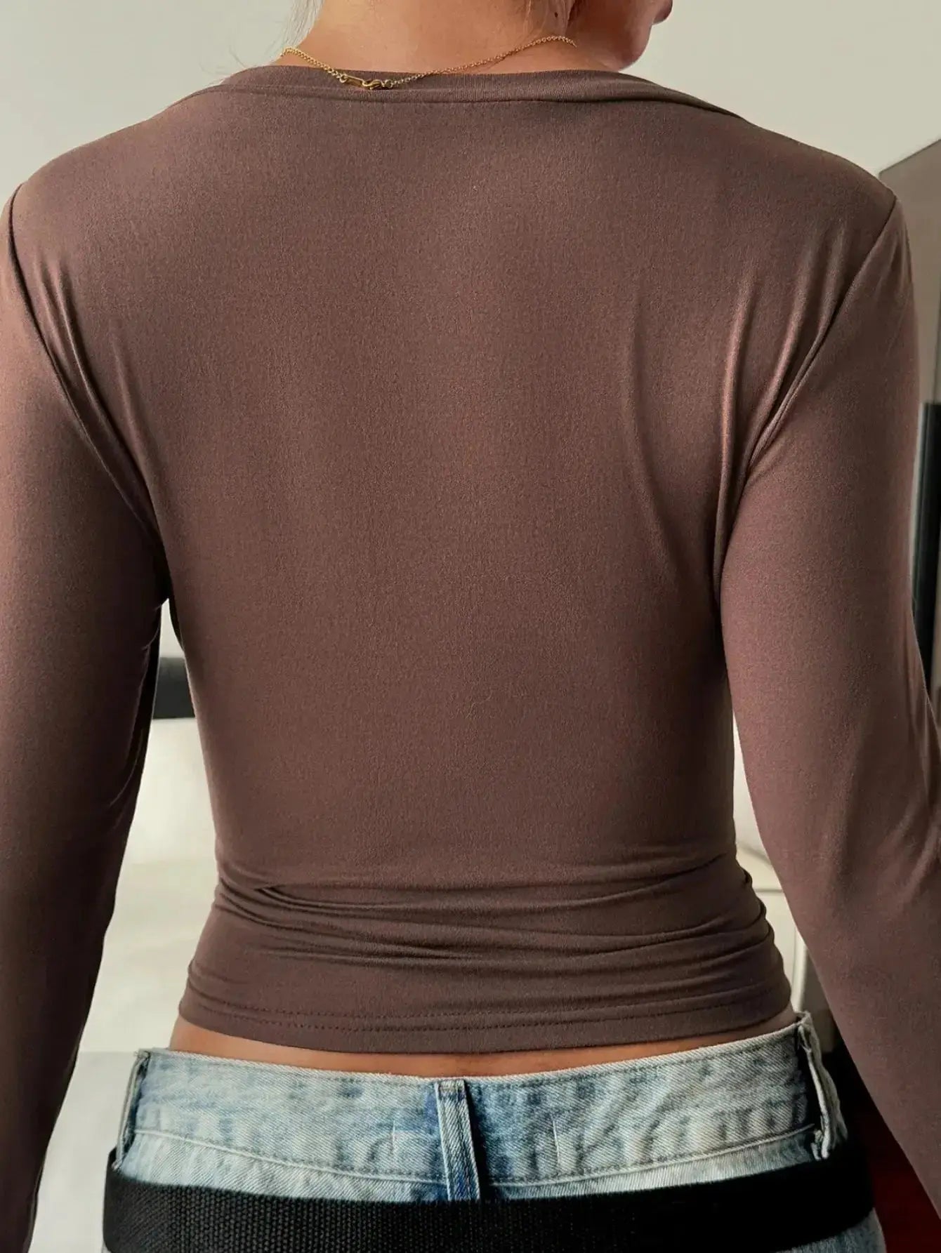 Women’s fitted V-neck long sleeve T-shirt by Trendsi, showcasing a casual, comfortable essential in soft fabric with a flattering fit.