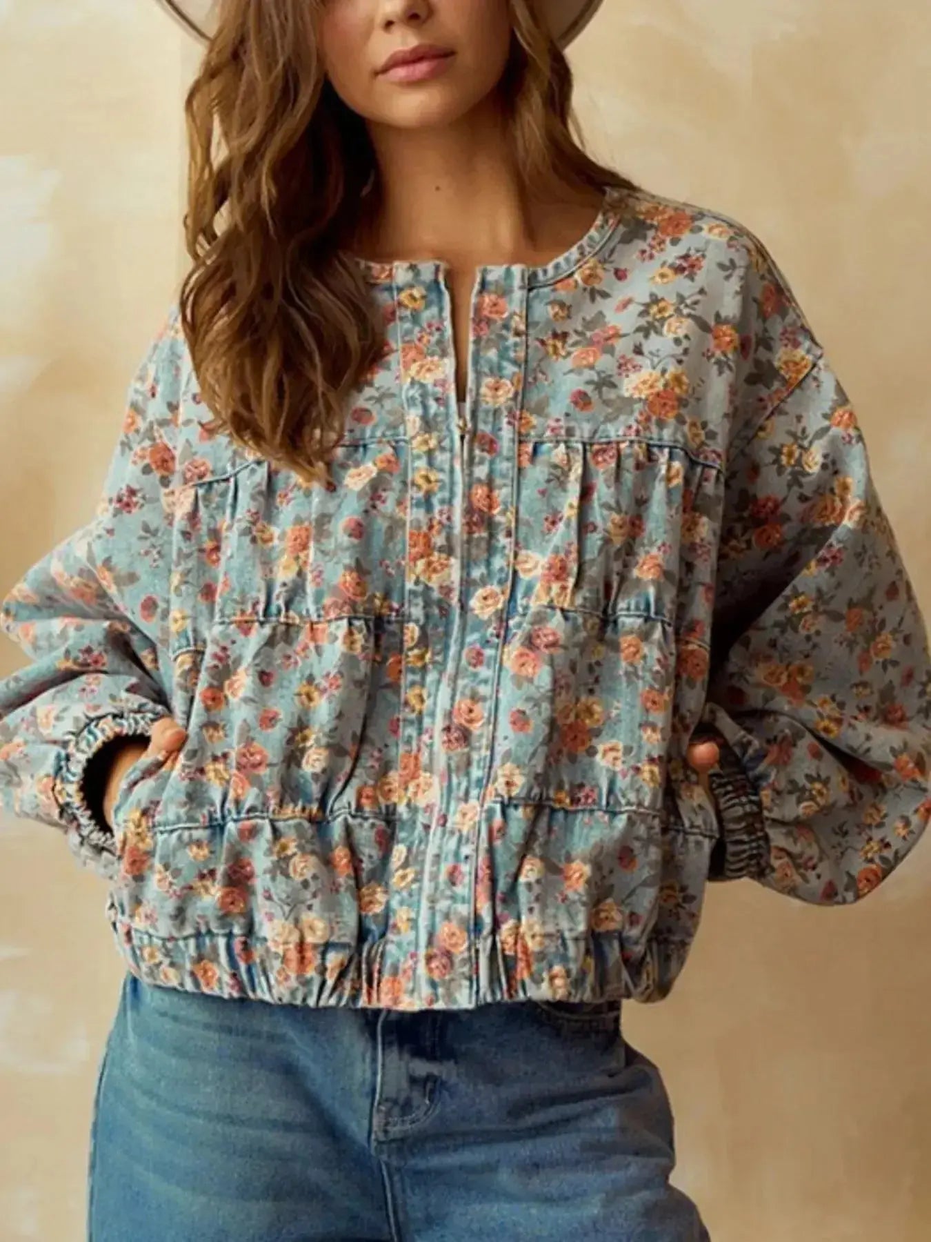 Women's floral print cropped denim jacket with zip-up front and utility style, made from cotton blend fabric.