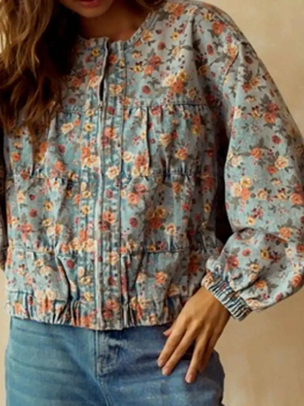 Women's floral print cropped denim jacket with zip-up front and utility style, made from cotton blend fabric.