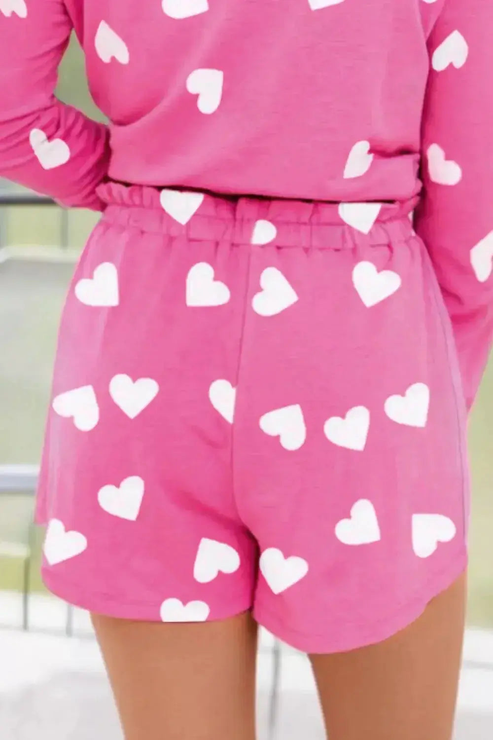 Women's heart print long sleeve pajama set with elastic waist shorts, featuring a cozy, comfortable design from Trendsi.