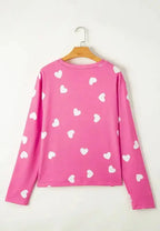 Women's heart print long sleeve pajama set with elastic waist shorts, featuring a cozy, feminine design from Trendsi.