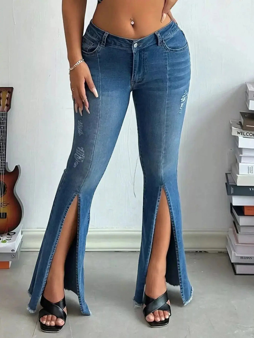 Women's high-rise distressed slit flare jeans with vintage-inspired denim, featuring a fitted waist and flared legs.