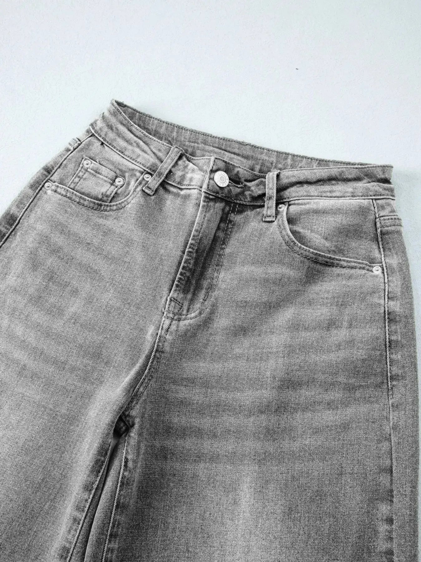 Women’s high-waisted wide-leg washed denim jeans with a relaxed fit, shown on a model, featuring classic denim styling by Trendsi.