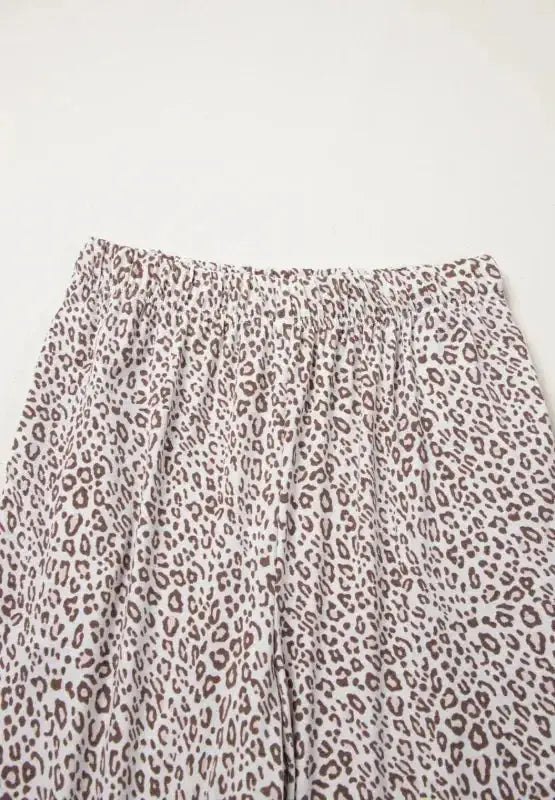 Women's leopard print button-down long sleeve pajama lounge set by Trendsi, featuring a stylish and comfortable pajama top and bottoms.
