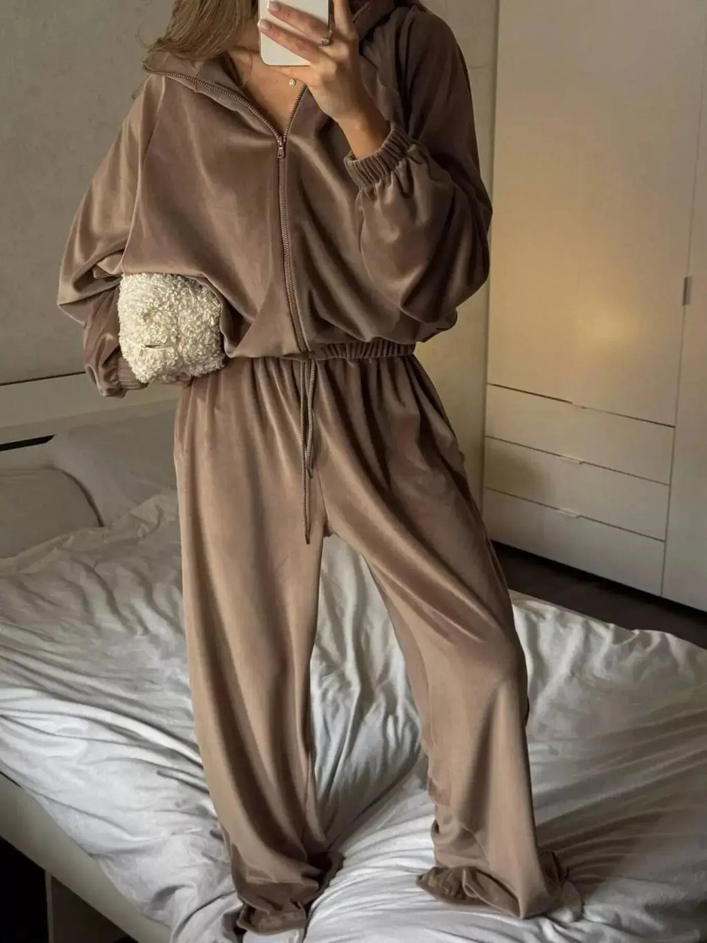 Women's plush long sleeve zip-up jacket and matching pants lounge set by Trendsi, cozy and stylish for relaxed wear.
