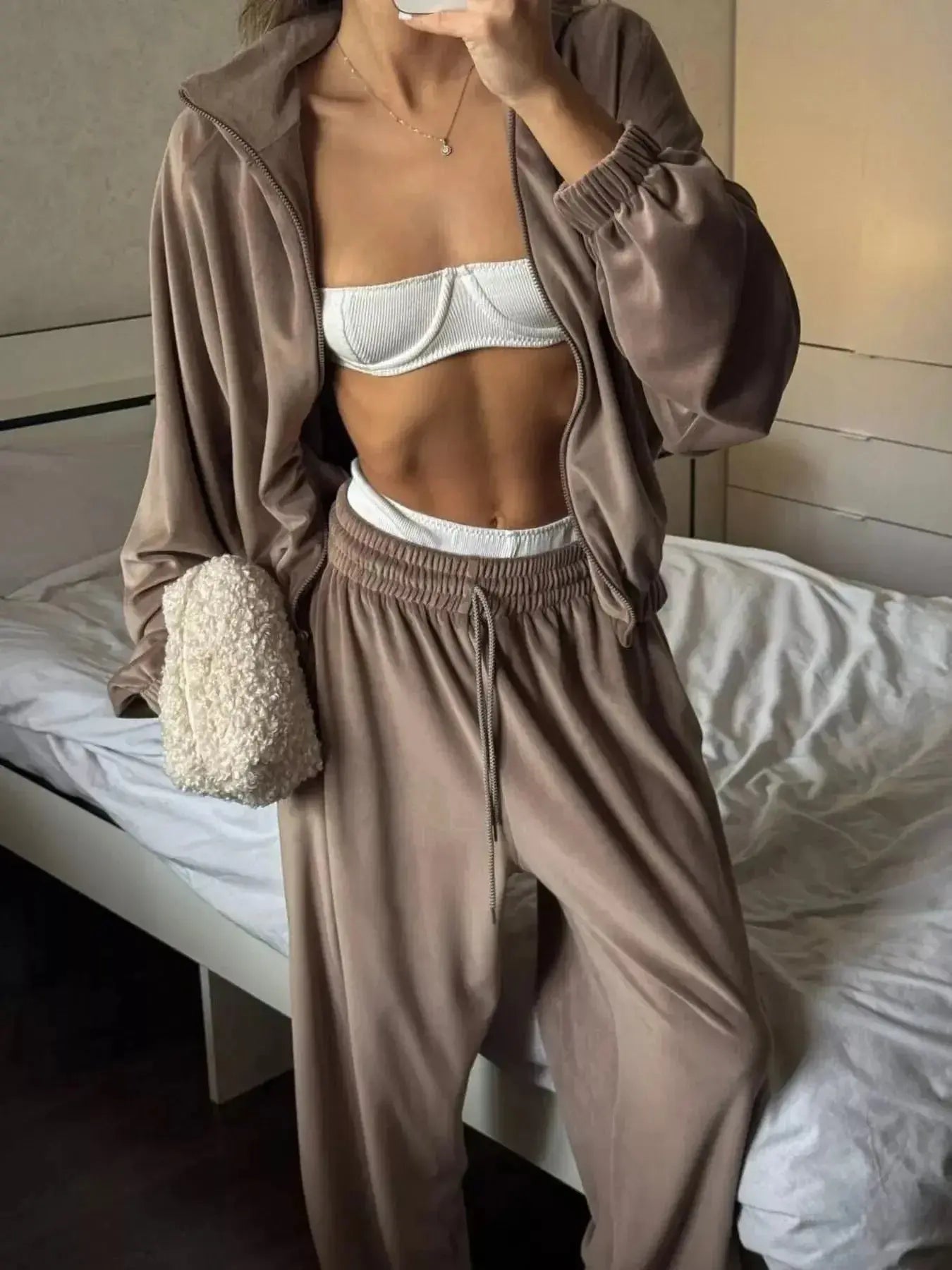 Women's long sleeve zip-up jacket and pants lounge set by Trendsi, plush fabric, comfortable casual wear.